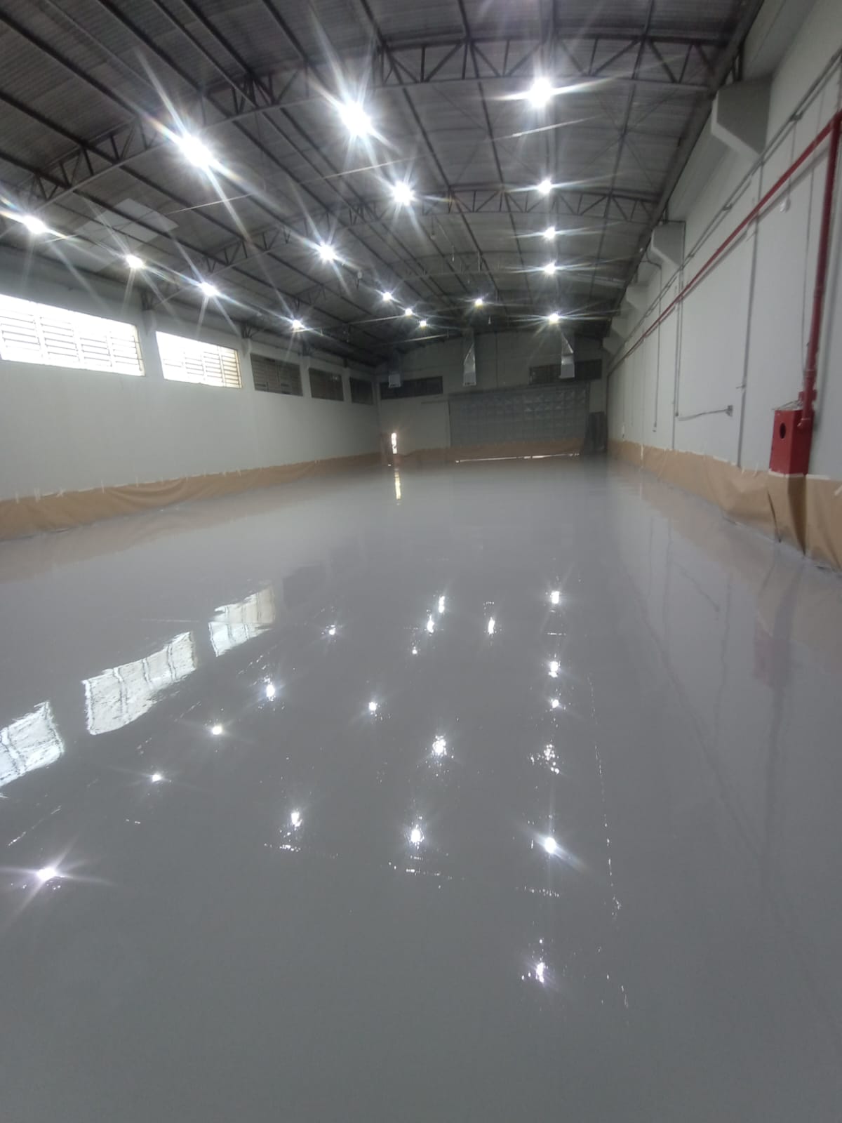 Piso de estacionamento com pintura epóxi cinza e faixas amarelas